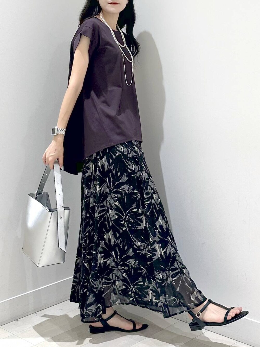 シルバー系のショルダーバッグ、ブラック系のサンダル、ブラウン系のTシャツ/カットソーを着用したレディースの夏コーディネートの2枚目の写真