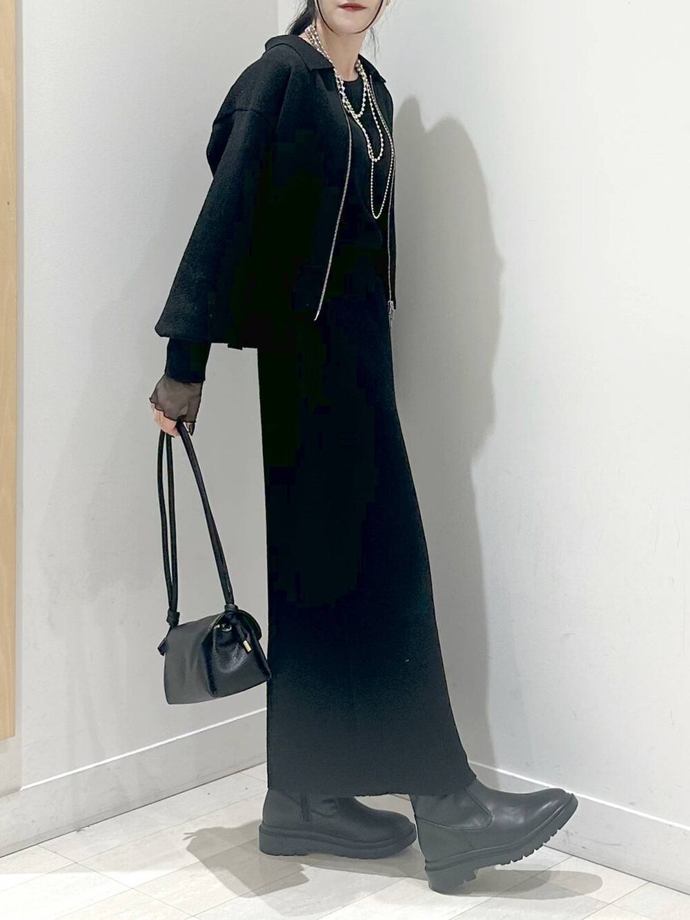 ブラック系のワンピース、ブラック系のショルダーバッグ、ブラック系のTシャツ/カットソーを着用したレディースの秋コーディネートの2枚目の写真