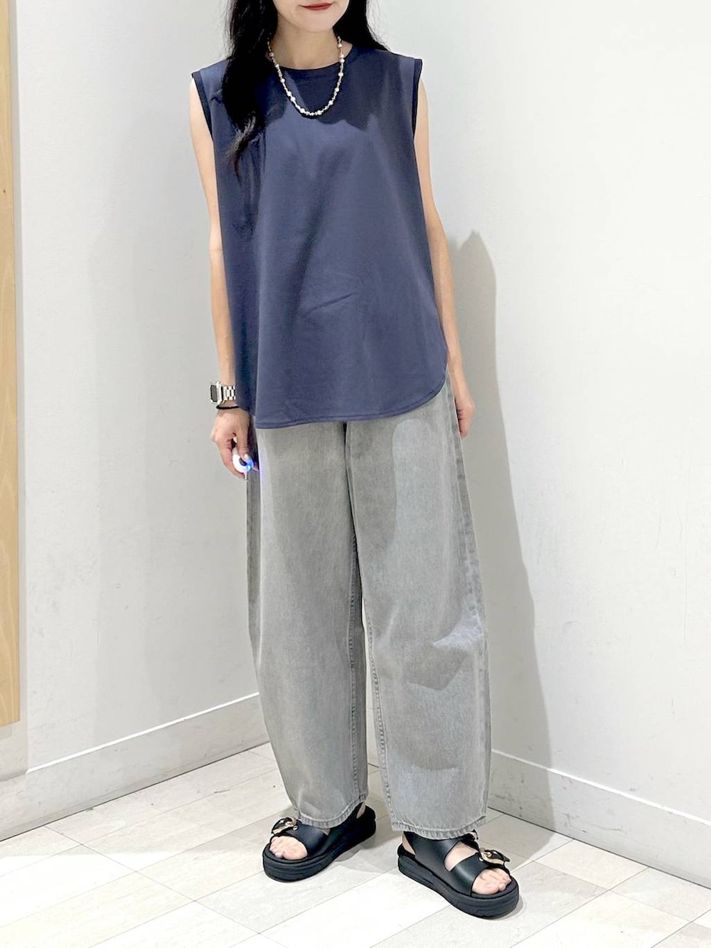 グレー系のデニムパンツ、ブラック系のサンダルを着用したレディースの夏コーディネートの4枚目の写真