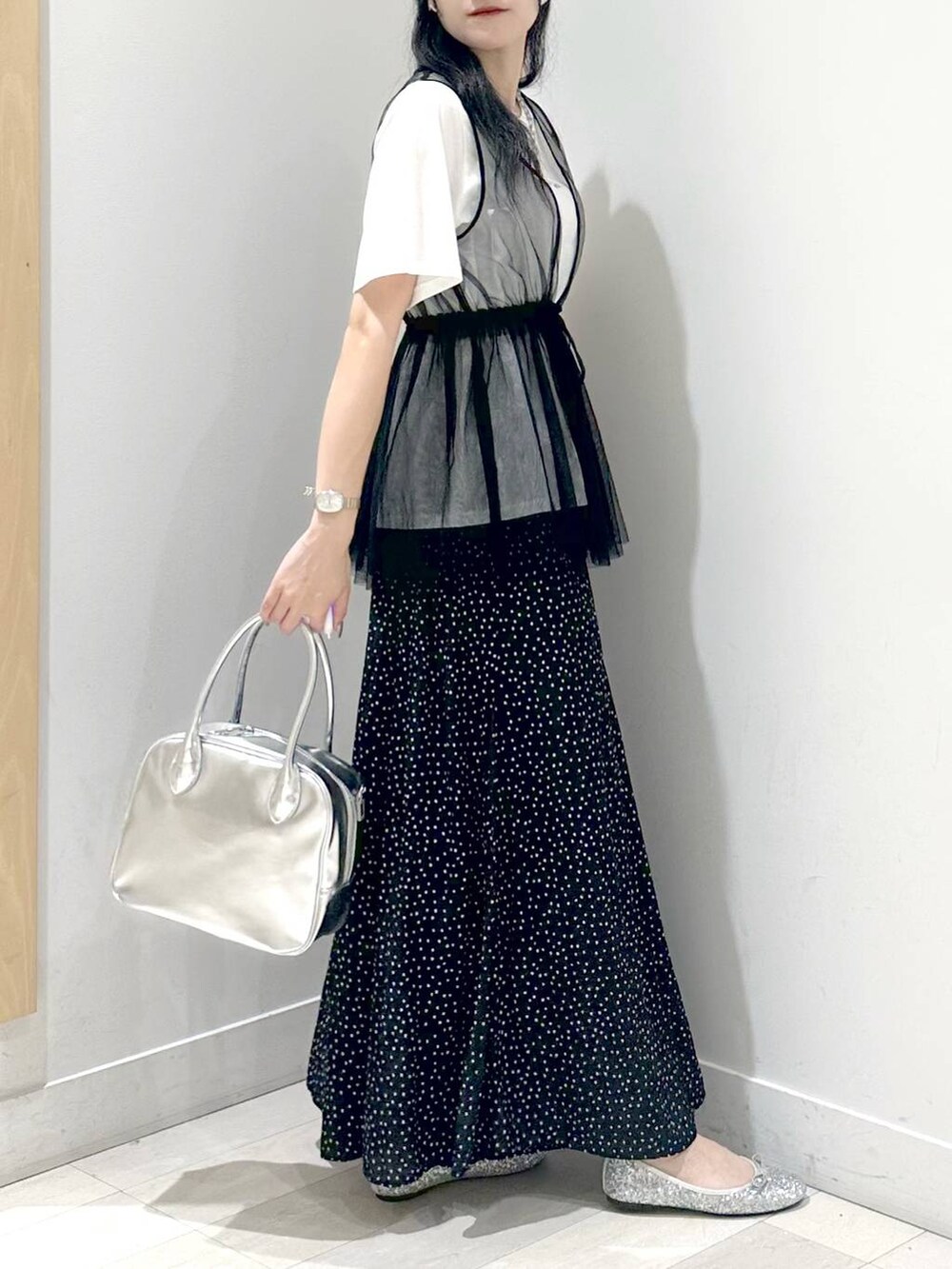 シルバー系のバレエシューズ、ブラック系のその他パンツ、グレー系のボストンバッグを着用したレディースの夏コーディネートの2枚目の写真