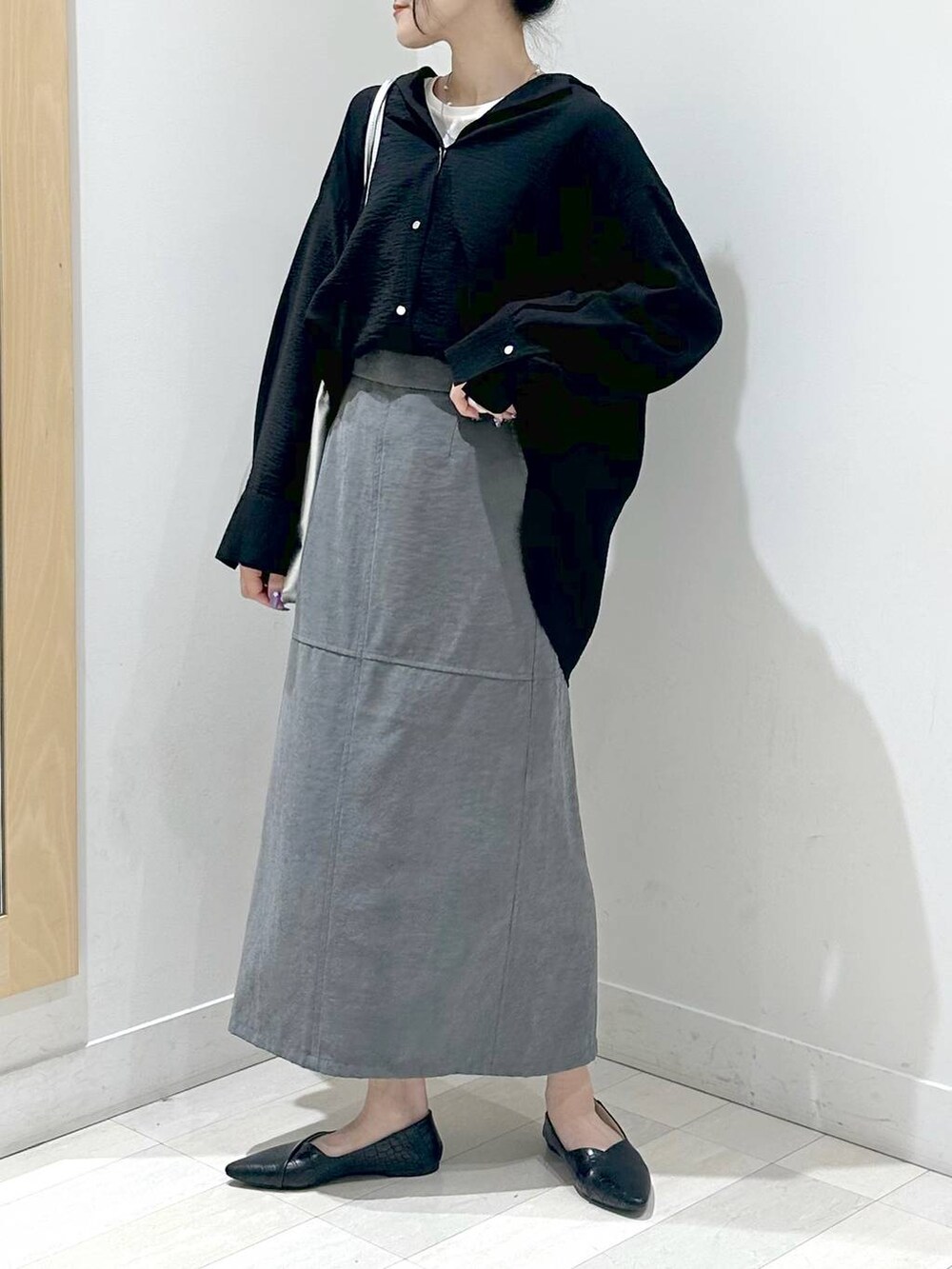 ブラック系のパンプス、ブラック系のシャツ/ブラウス、グレー系のスカートを着用したレディースの秋コーディネートの4枚目の写真