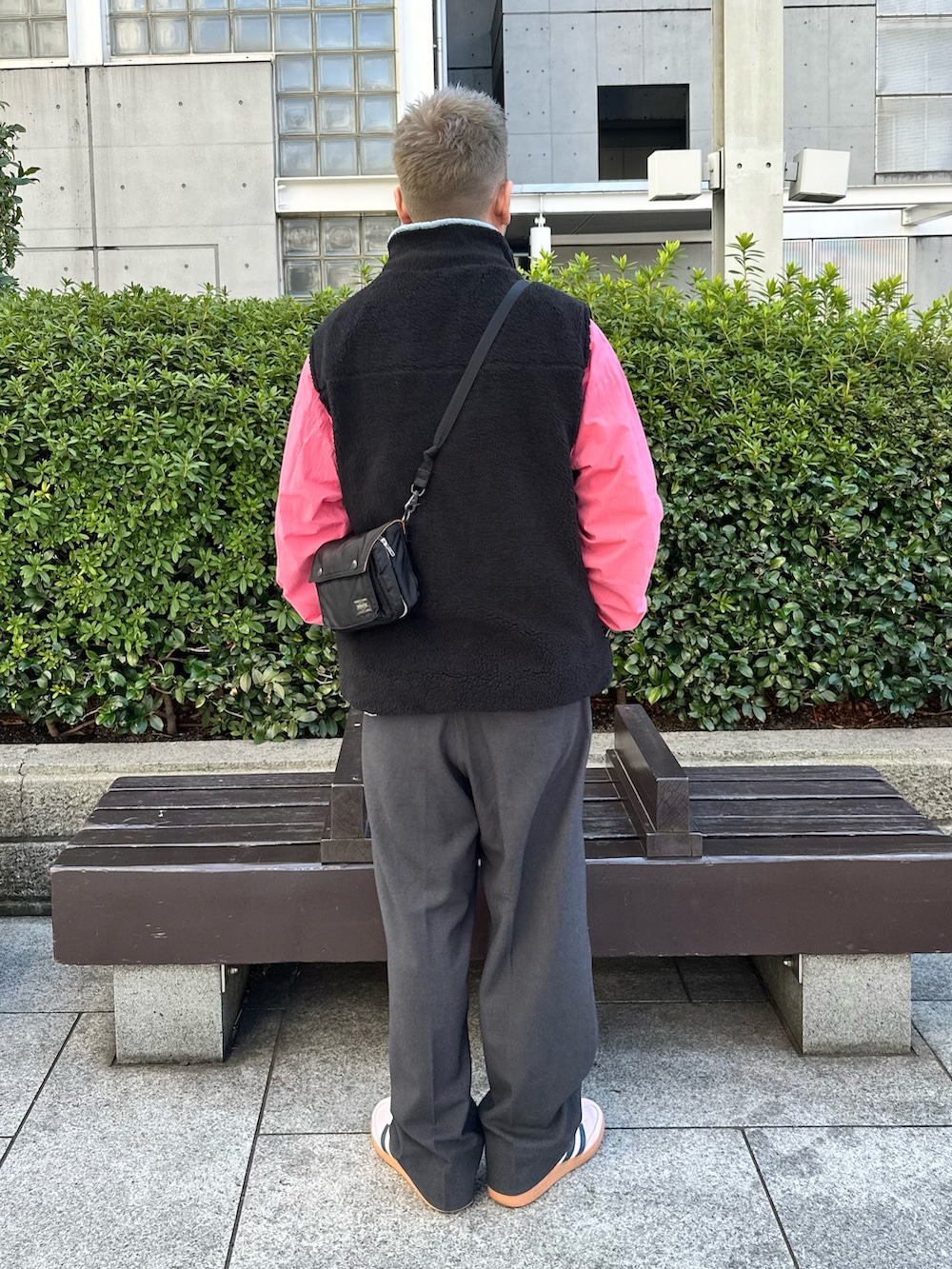 ブラック系のベスト、ピンク系のブルゾン、ホワイト系のTシャツ/カットソーを着用したメンズの春コーディネートの2枚目の写真