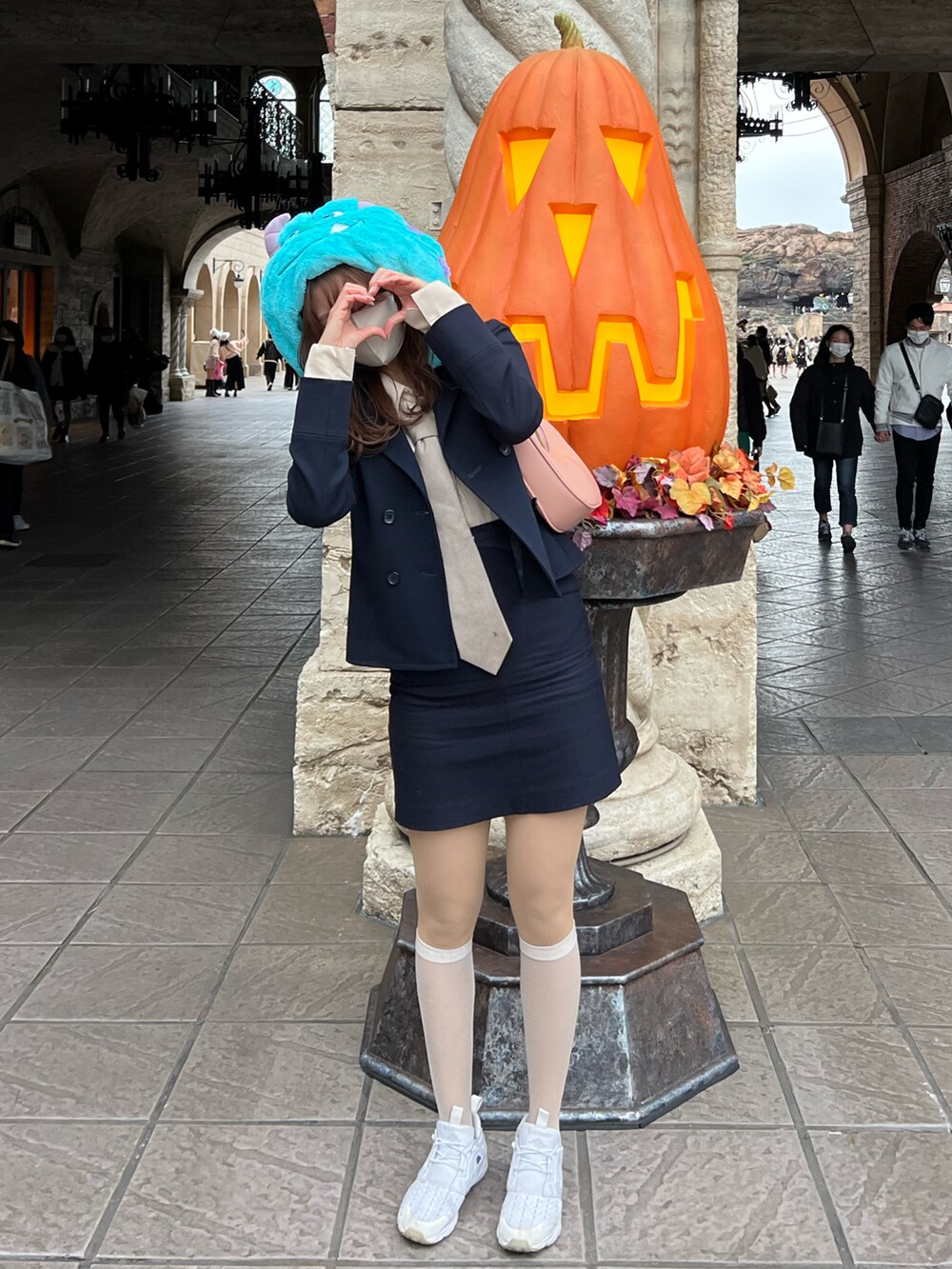 ブルー系のスカート、ピンク系のショルダーバッグ、ベージュ系のソックス/靴下を着用したレディースの秋コーディネートの2枚目の写真