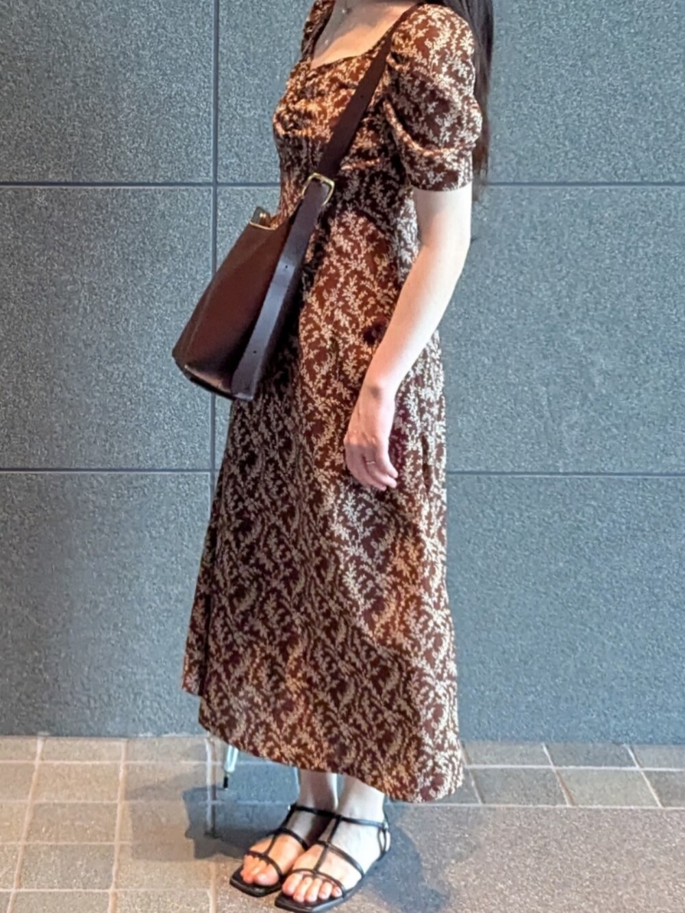 ブラウン系のワンピース、ブラウン系のトートバッグ、シルバー系のネックレスを着用したレディースの夏コーディネートの2枚目の写真