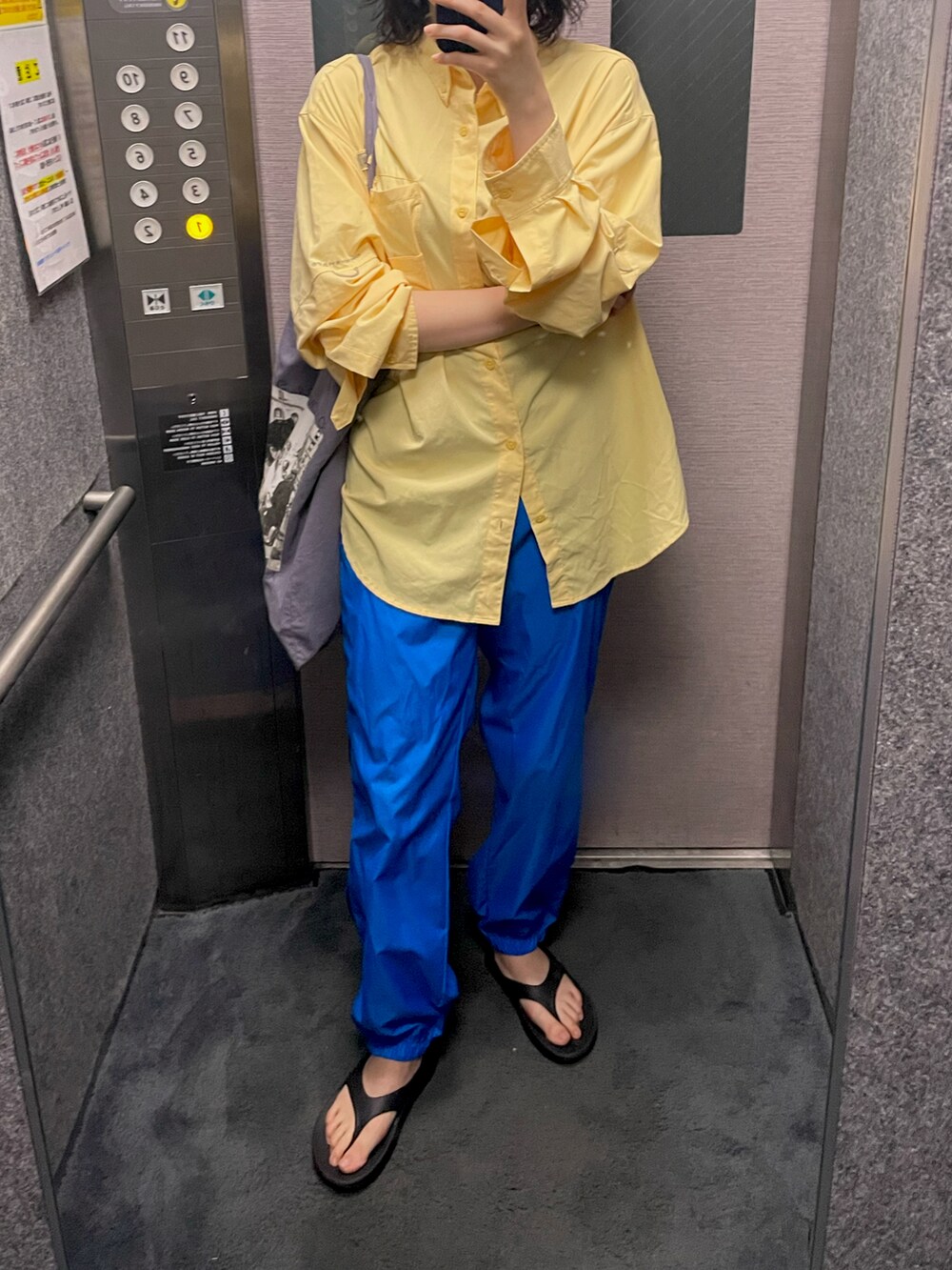 イエロー系のシャツ/ブラウス、シルバー系のピアス（両耳用）を着用したレディースの夏コーディネートの2枚目の写真