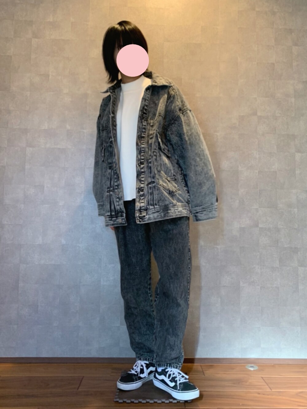 ホワイト系のニット/セーター、ブラック系のブルゾン、ブルー系のデニムパンツを着用したレディースの冬コーディネートの2枚目の写真