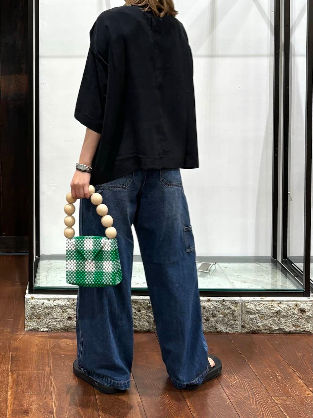 ブルー系のデニムパンツ、ブラック系のTシャツ/カットソー、その他のハンドバッグを着用したレディースの夏コーディネートの3枚目の写真