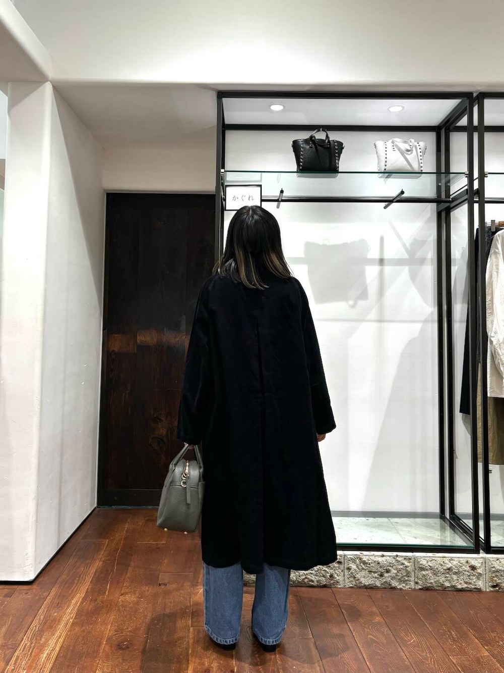 グリーン系のボストンバッグ、ブラック系のその他シューズ、ブラック系のステンカラーコートを着用したレディースの秋コーディネートの3枚目の写真