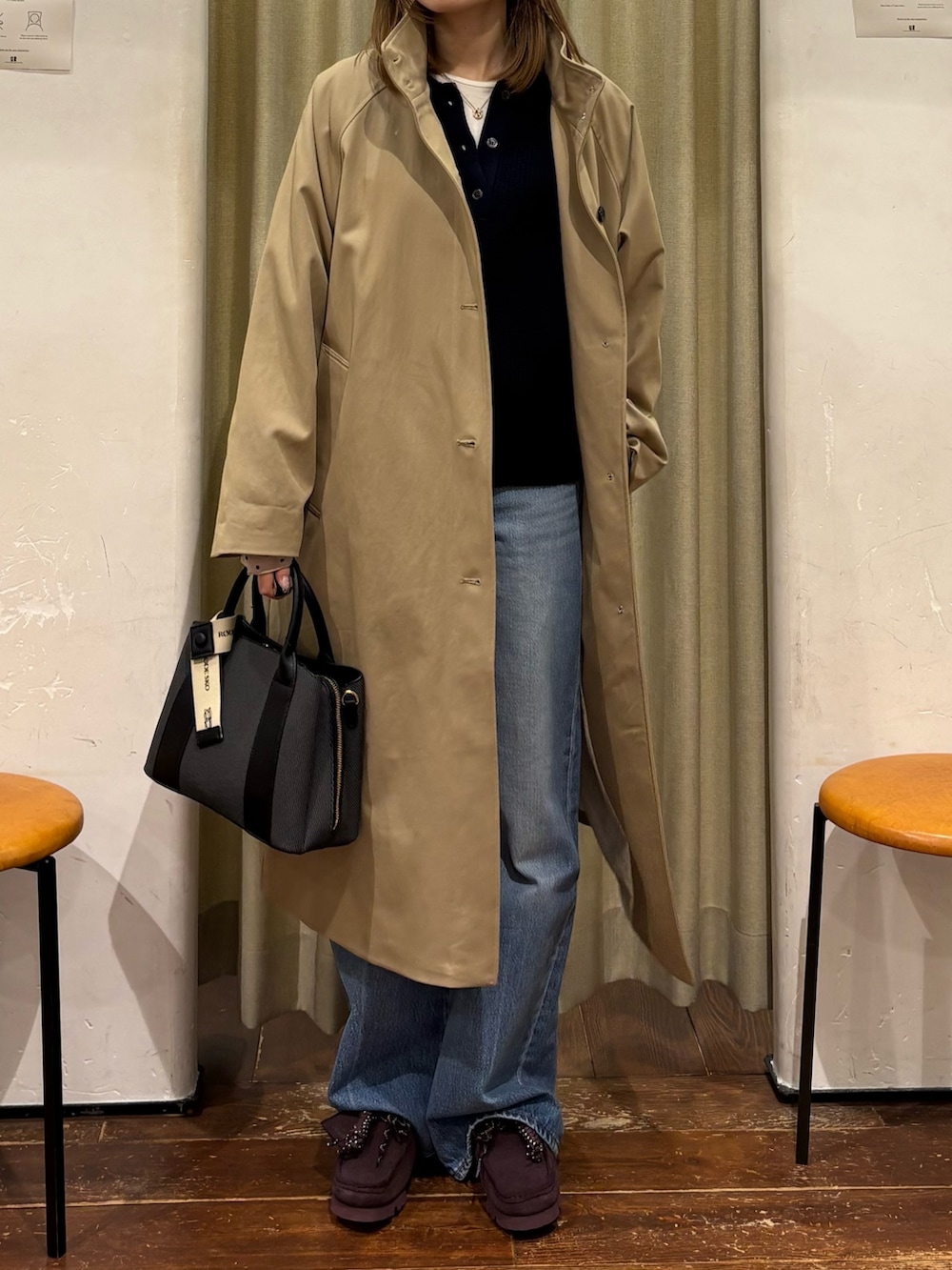 ブルー系のニット/セーター、ブルー系のデニムパンツ、ブラック系のハンドバッグを着用したレディースの冬コーディネートの5枚目の写真