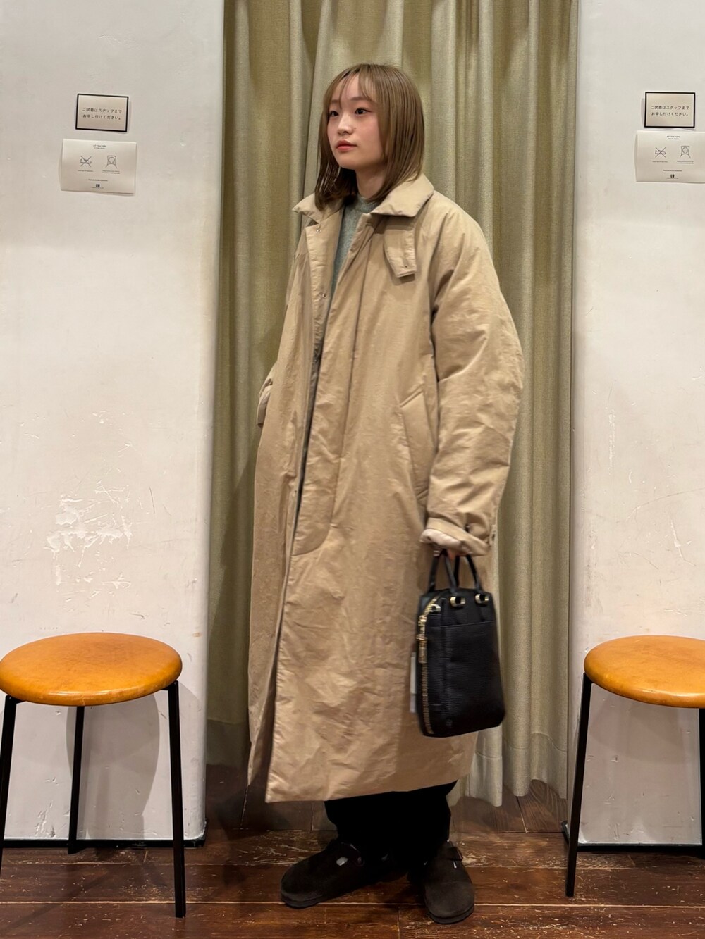 グリーン系のニット/セーター、ベージュ系のダウンジャケット/コート、ブラック系のその他パンツを着用したレディースの冬コーディネートの2枚目の写真