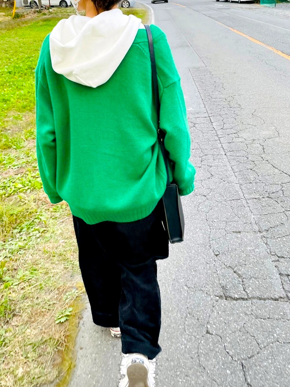 ブラック系のショルダーバッグ、ホワイト系のスニーカー、グリーン系のカーディガン/ボレロを着用したレディースの秋コーディネートの2枚目の写真