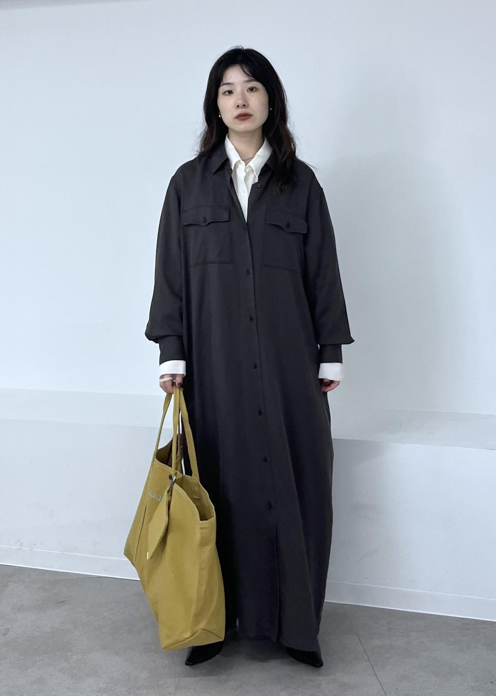 ホワイト系のシャツ/ブラウス、グレー系のワンピース、ブラック系のブーツを着用したレディースの秋コーディネートの3枚目の写真