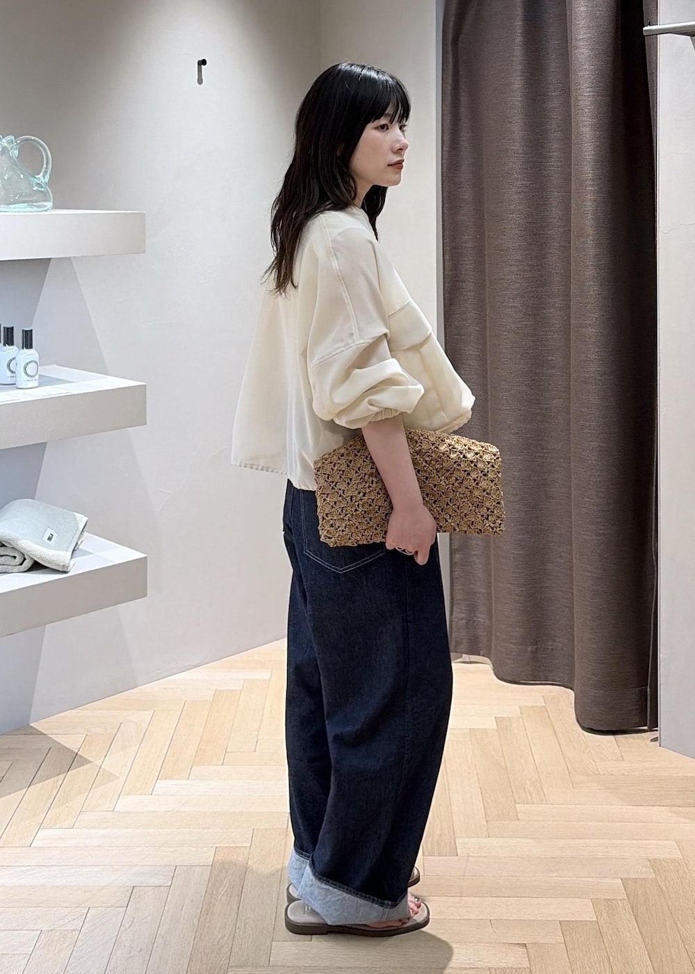 ベージュ系のサンダル、ブラウン系のハンドバッグ、ブルー系のデニムパンツを着用したレディースの夏コーディネートの3枚目の写真
