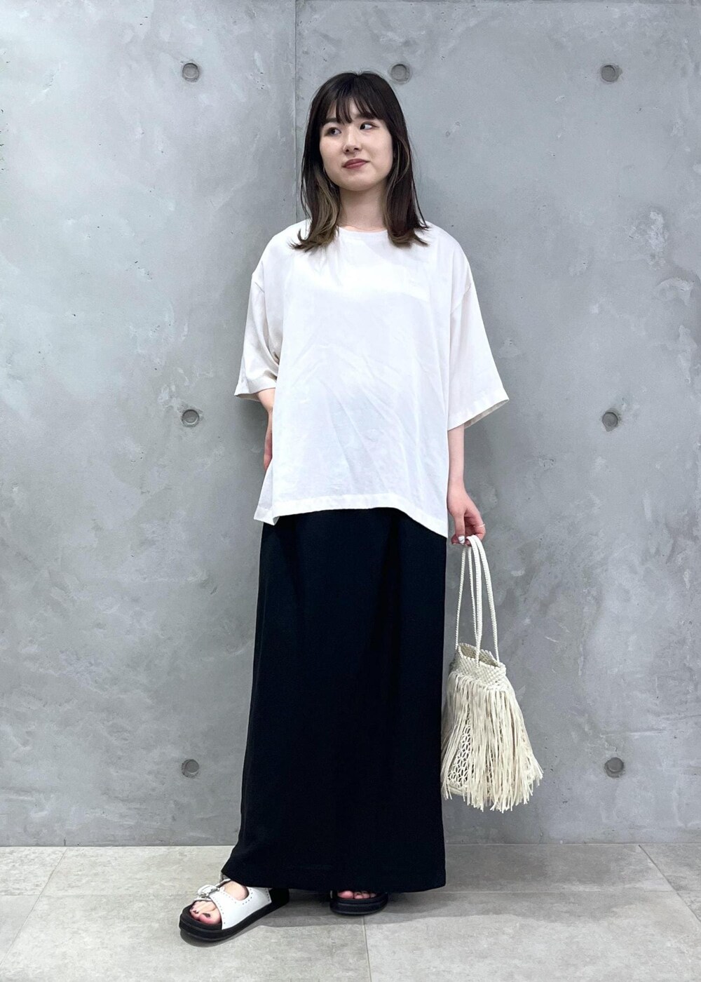 ホワイト系のTシャツ/カットソー、ホワイト系のサンダル、ホワイト系のトートバッグを着用したレディースの春コーディネートの3枚目の写真