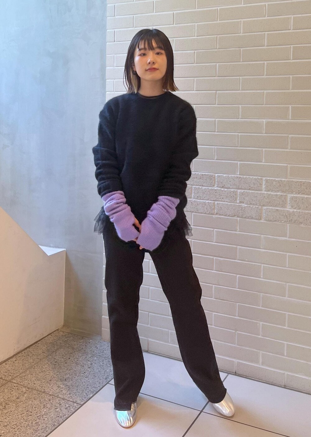 ブラック系のニット/セーター、ブラック系のベスト、グレー系のデニムパンツを着用したレディースの秋コーディネートの6枚目の写真