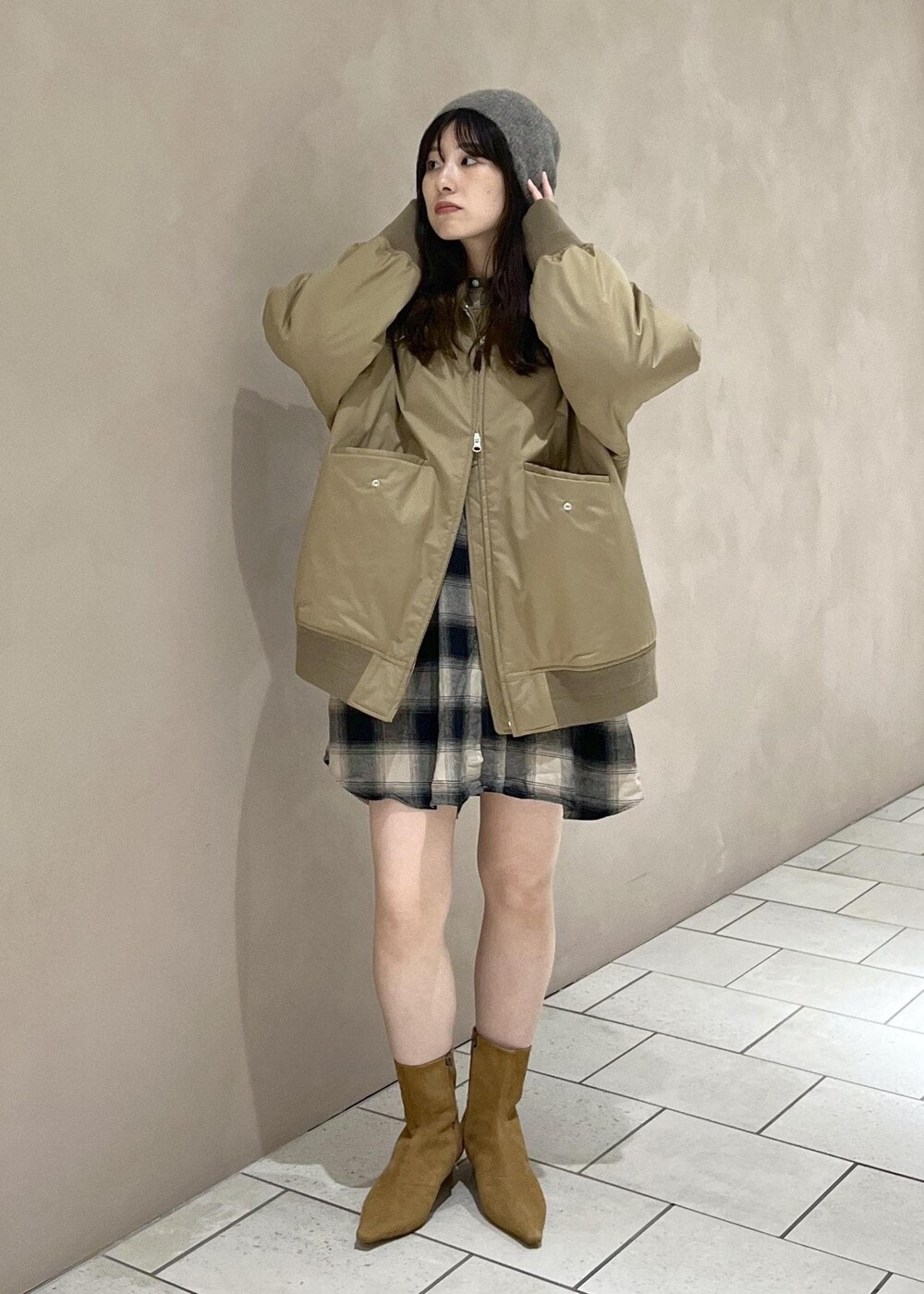 イエロー系のブーツ、ベージュ系のダウンジャケット/コート、ベージュ系のシャツ/ブラウスを着用したレディースの秋コーディネートの3枚目の写真