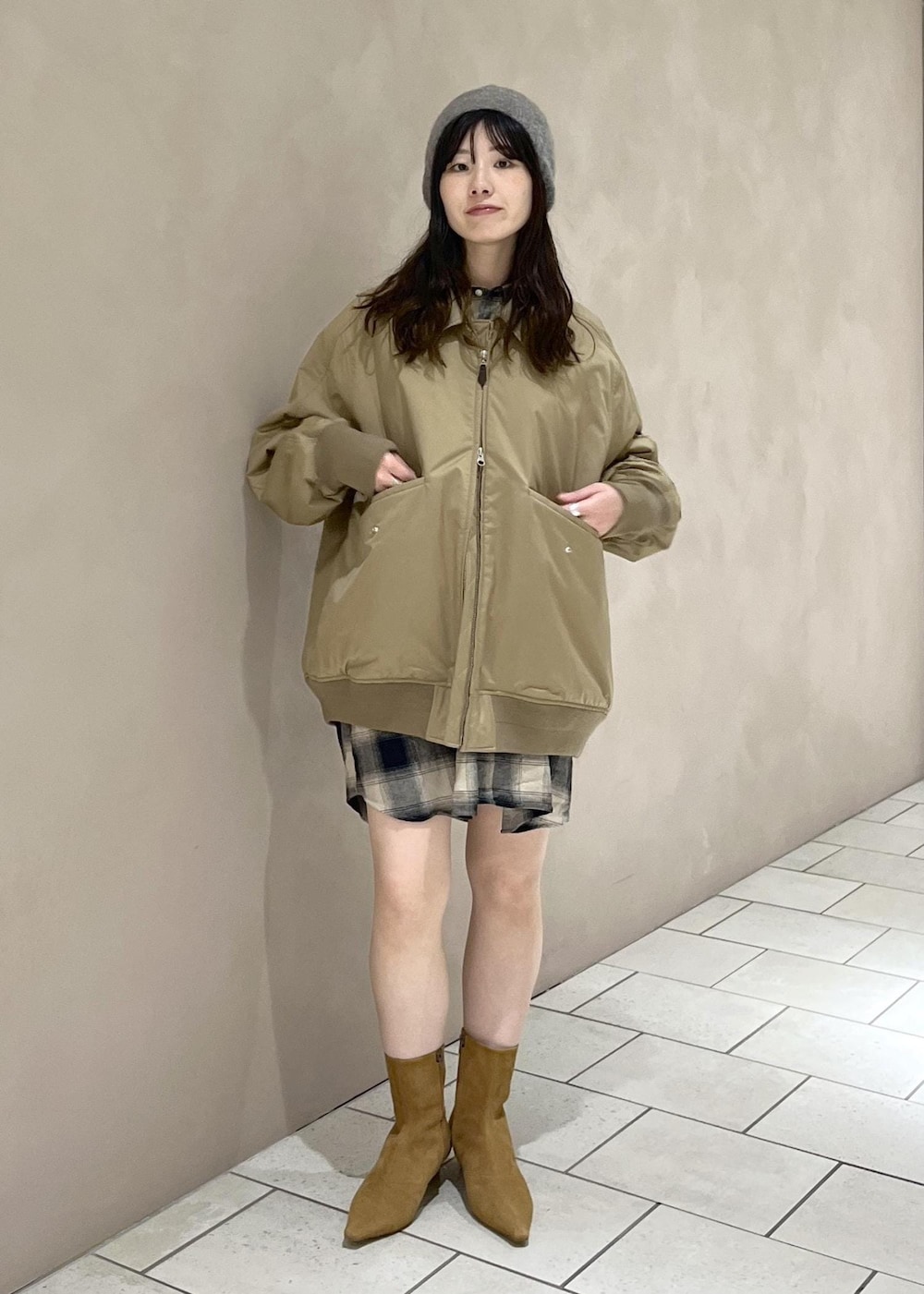 イエロー系のブーツ、ベージュ系のダウンジャケット/コート、ベージュ系のシャツ/ブラウスを着用したレディースの秋コーディネートの2枚目の写真