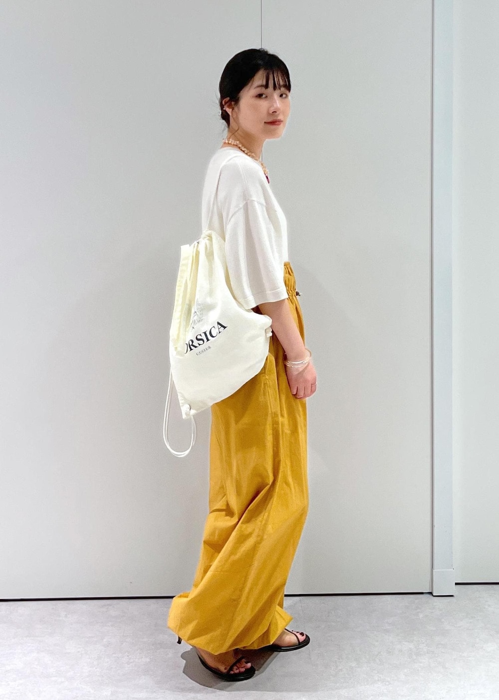 「Baserange、ワイドパンツ、キャメル、BRENTELLA、ミュール、メッシュ、オフホワイト、ナップサック、リュック、extreme cashmere、Tシャツ、Raponesa General Store、ネックレス、パール、初春コーデ」｜「SALON adam et rope'のナップサック（トートバッグ、ホワイト系）」を使った、michiruさん（レディース・156cm）の冬コーディネートの7枚目の写真