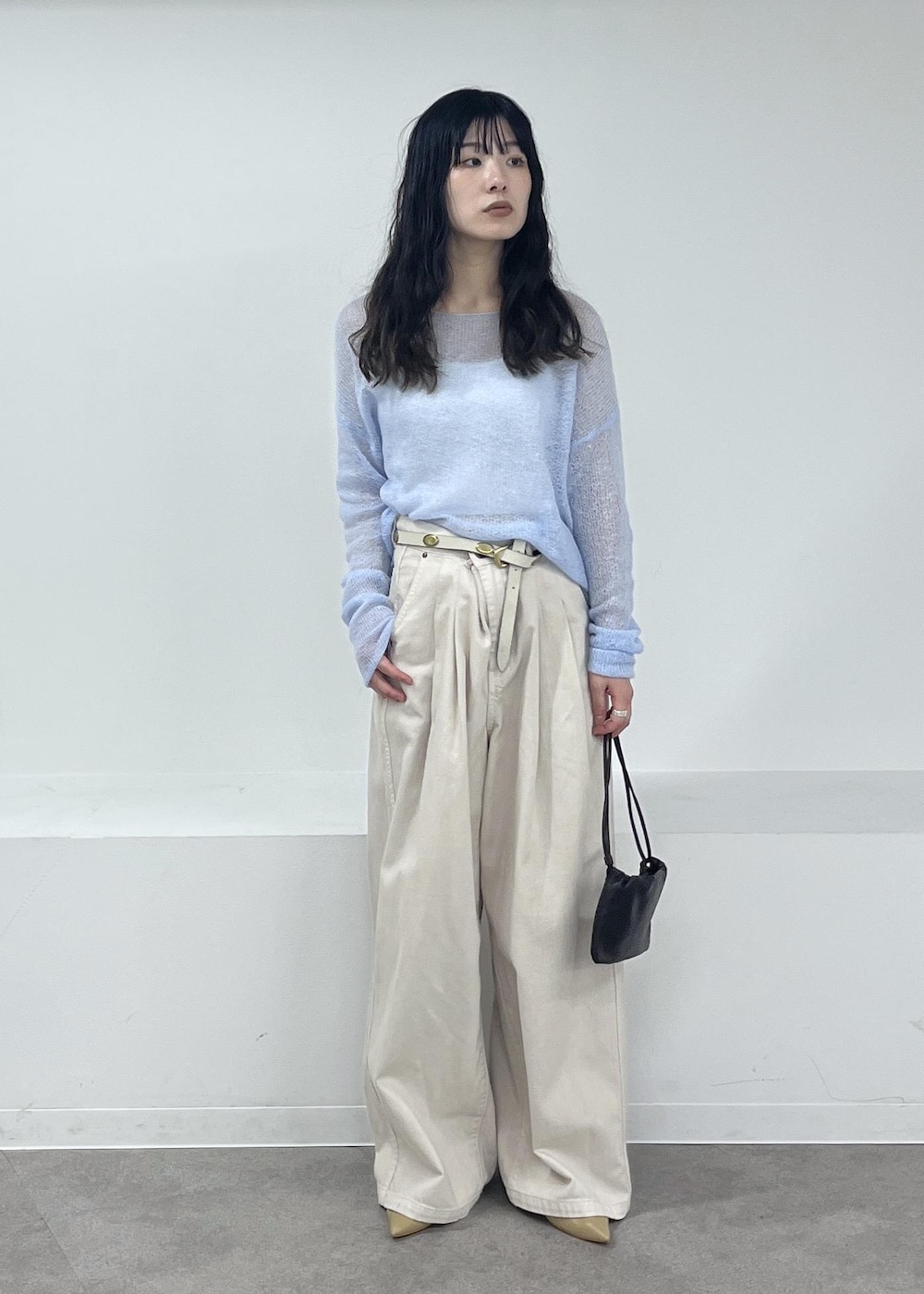 ホワイト系のデニムパンツ、ブルー系のニット/セーター、ベージュ系のパンプスを着用したレディースの冬コーディネートの6枚目の写真