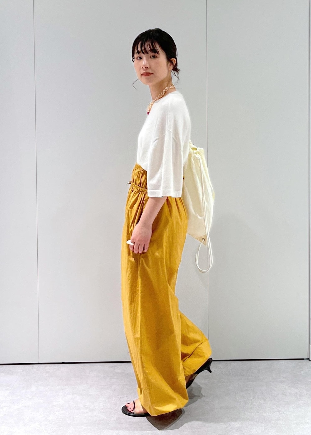 「Baserange、ワイドパンツ、キャメル、BRENTELLA、ミュール、メッシュ、オフホワイト、ナップサック、リュック、extreme cashmere、Tシャツ、Raponesa General Store、ネックレス、パール、初春コーデ」｜「SALON adam et rope'のナップサック（トートバッグ、ホワイト系）」を使った、michiruさん（レディース・156cm）の冬コーディネートの6枚目の写真