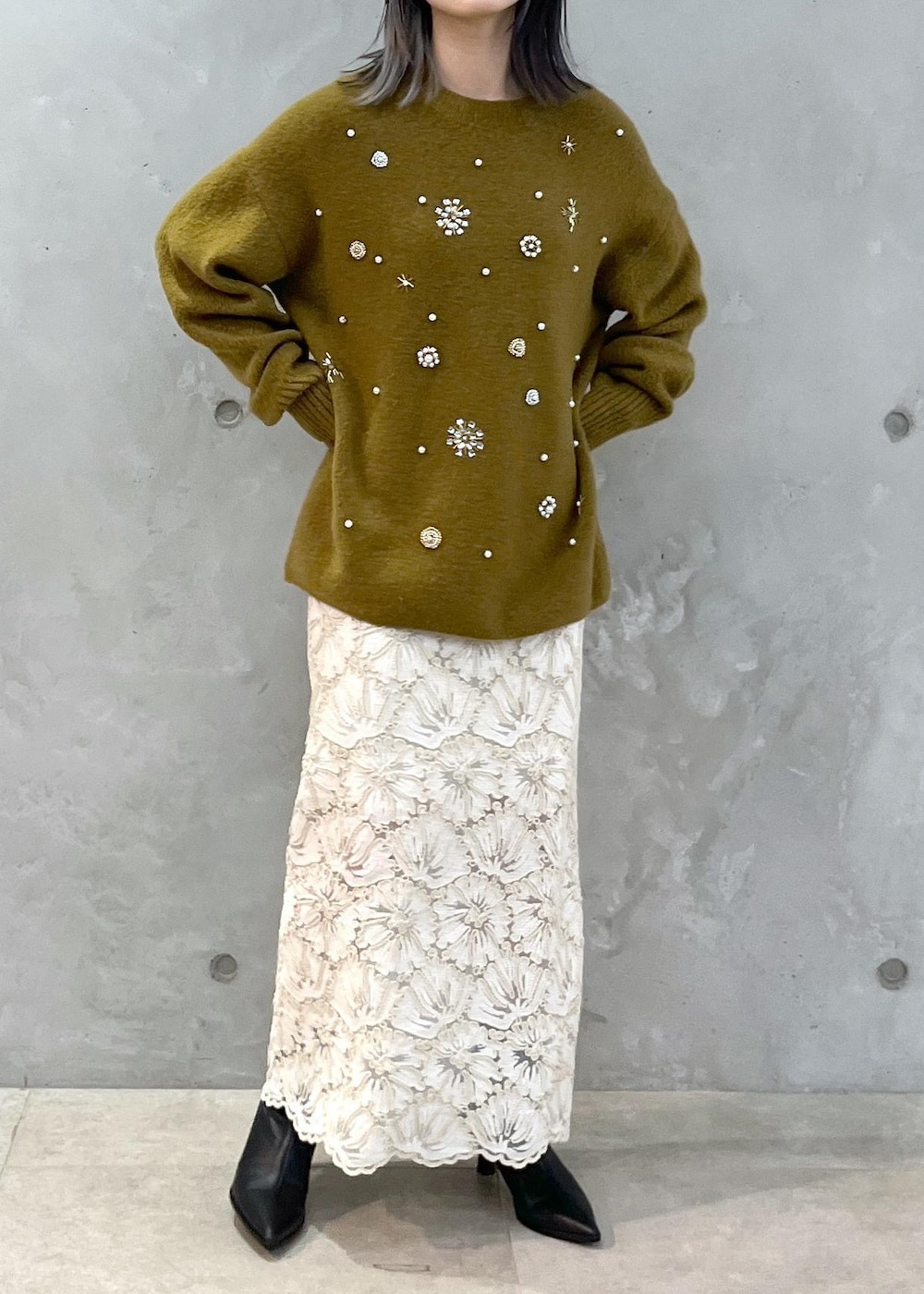 ブラック系のショルダーバッグ、ベージュ系のスカート、イエロー系のニット/セーターを着用したレディースの秋コーディネートの8枚目の写真