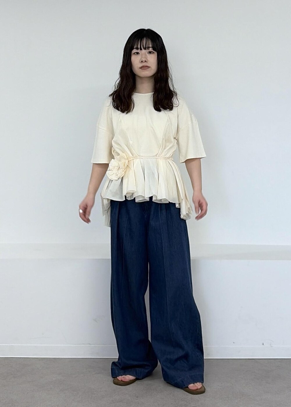 ベージュ系のショルダーバッグ、ブルー系のデニムパンツ、ブラウン系のサンダルを着用したレディースの冬コーディネートの7枚目の写真