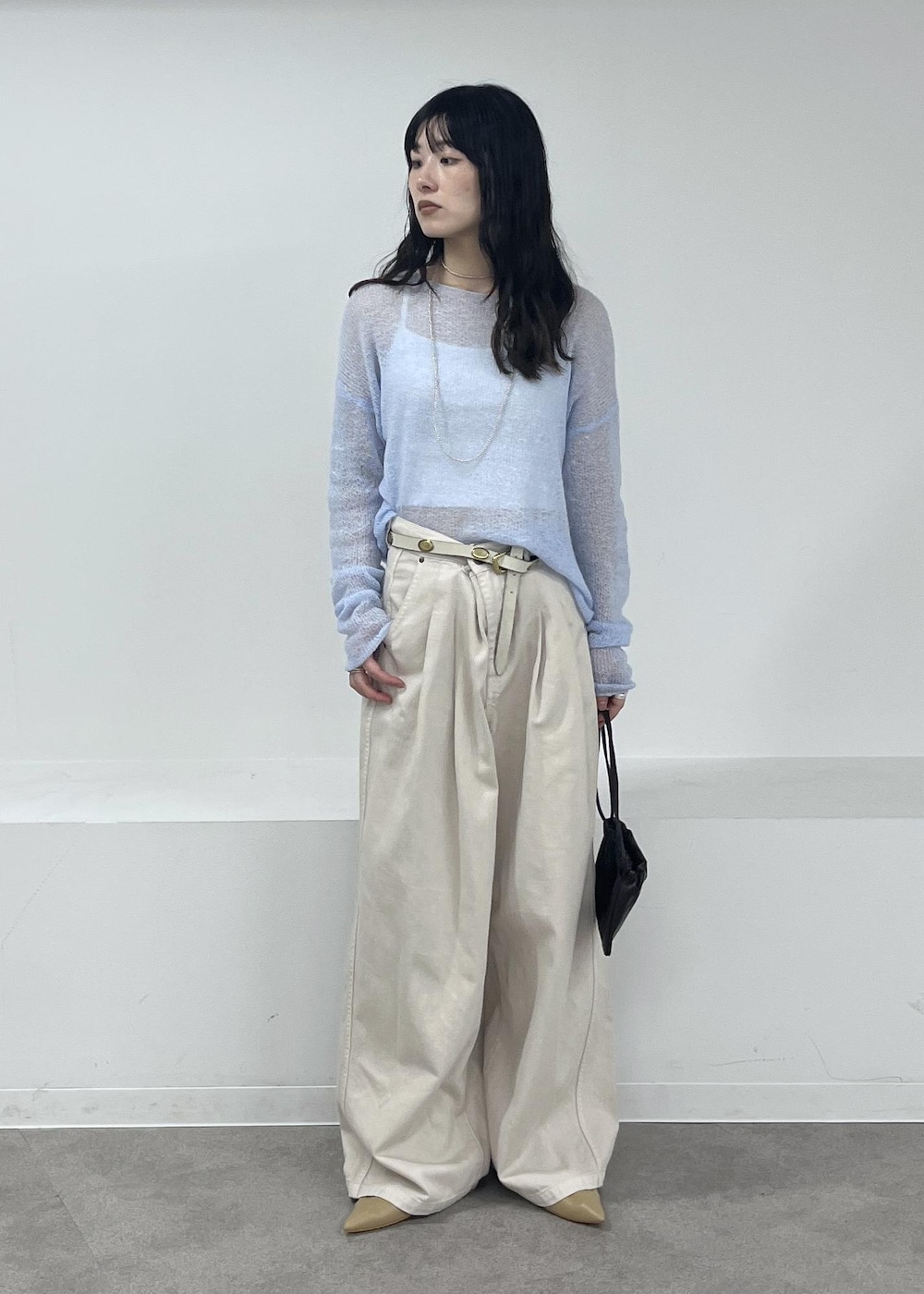 ホワイト系のデニムパンツ、ブルー系のニット/セーター、ベージュ系のパンプスを着用したレディースの冬コーディネートの2枚目の写真