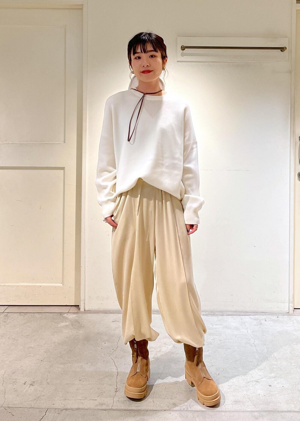 ベージュ系のブーツ、ベージュ系のその他パンツ、ホワイト系のスウェットを着用したレディースの秋コーディネートの3枚目の写真