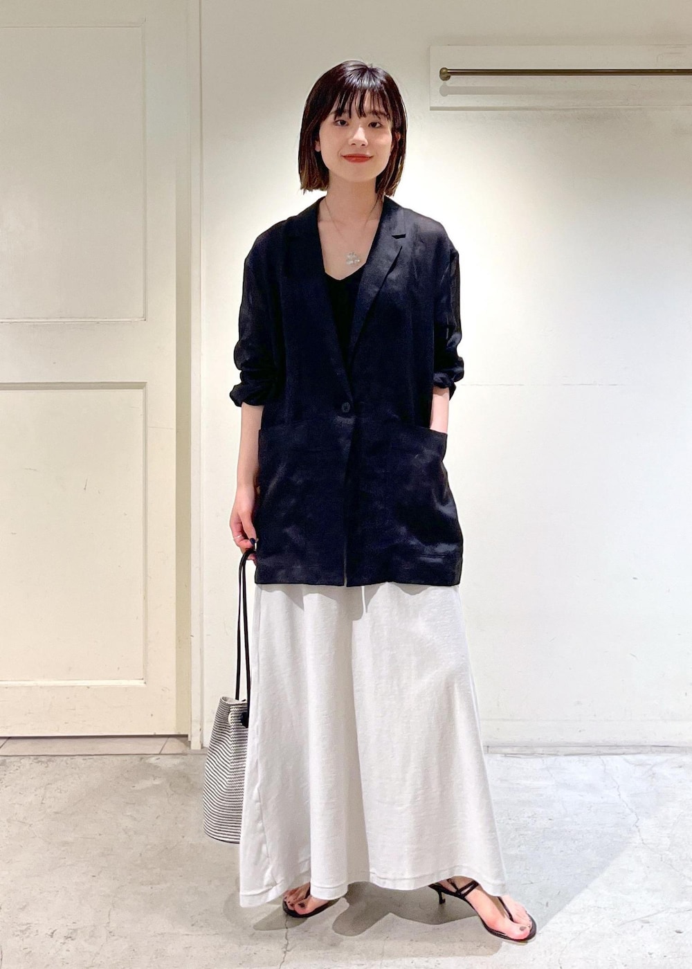 ブラック系のキャミソール、ブラック系のサンダル、ブラック系のショルダーバッグを着用したレディースの春コーディネートの2枚目の写真