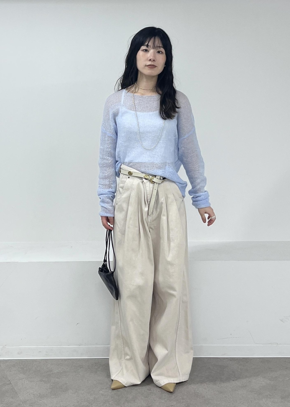 ホワイト系のデニムパンツ、ブルー系のニット/セーター、ベージュ系のパンプスを着用したレディースの冬コーディネートの7枚目の写真