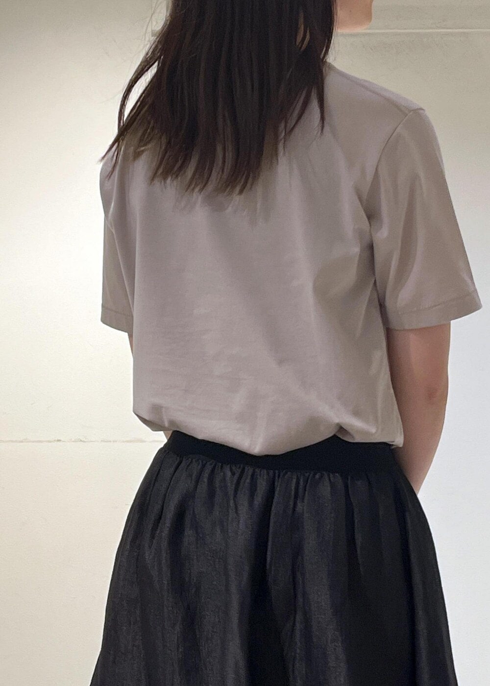 ブラック系のスカート、ベージュ系のTシャツ/カットソーを着用したレディースの夏コーディネートの7枚目の写真