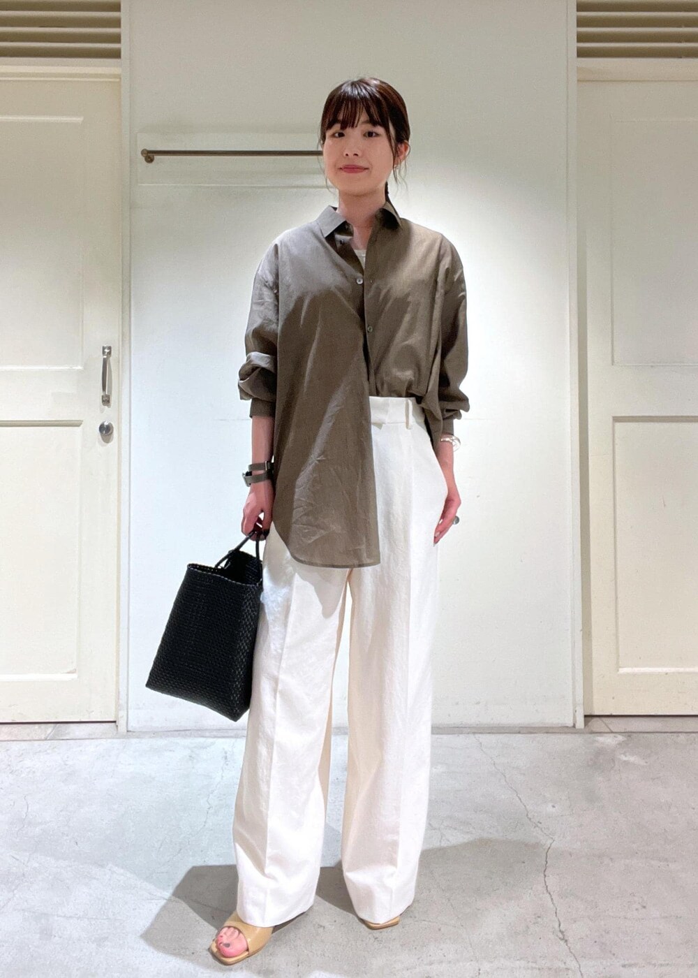 ブラウン系のシャツ/ブラウス、ホワイト系のTシャツ/カットソー、ブラック系のかごバッグを着用したレディースの春コーディネートの3枚目の写真