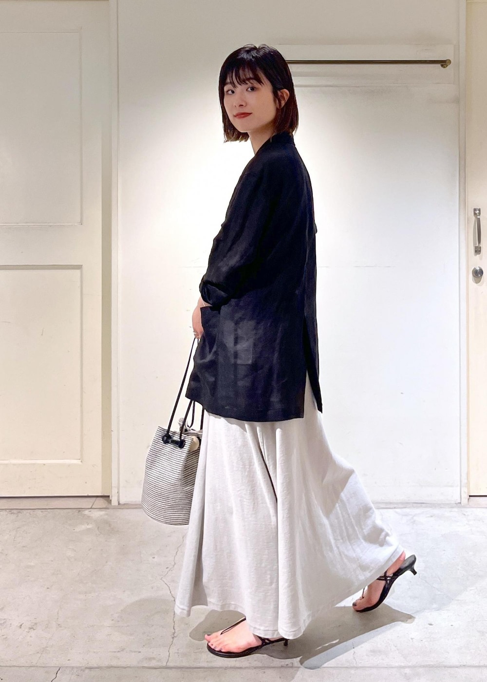 ブラック系のキャミソール、ブラック系のサンダル、ブラック系のショルダーバッグを着用したレディースの春コーディネートの8枚目の写真