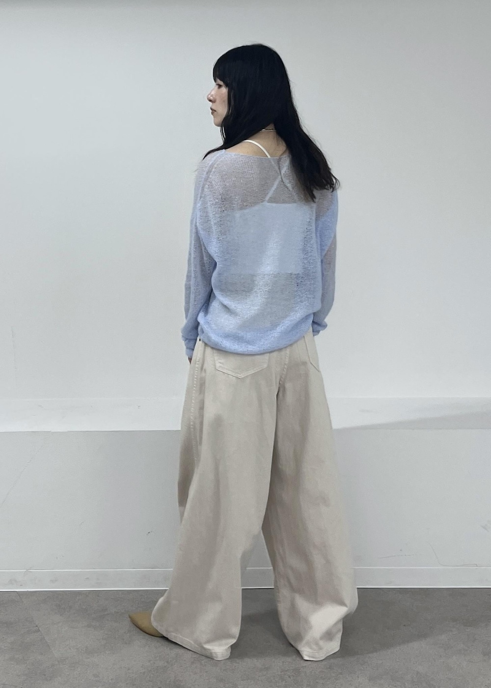 ホワイト系のデニムパンツ、ブルー系のニット/セーター、ベージュ系のパンプスを着用したレディースの冬コーディネートの5枚目の写真