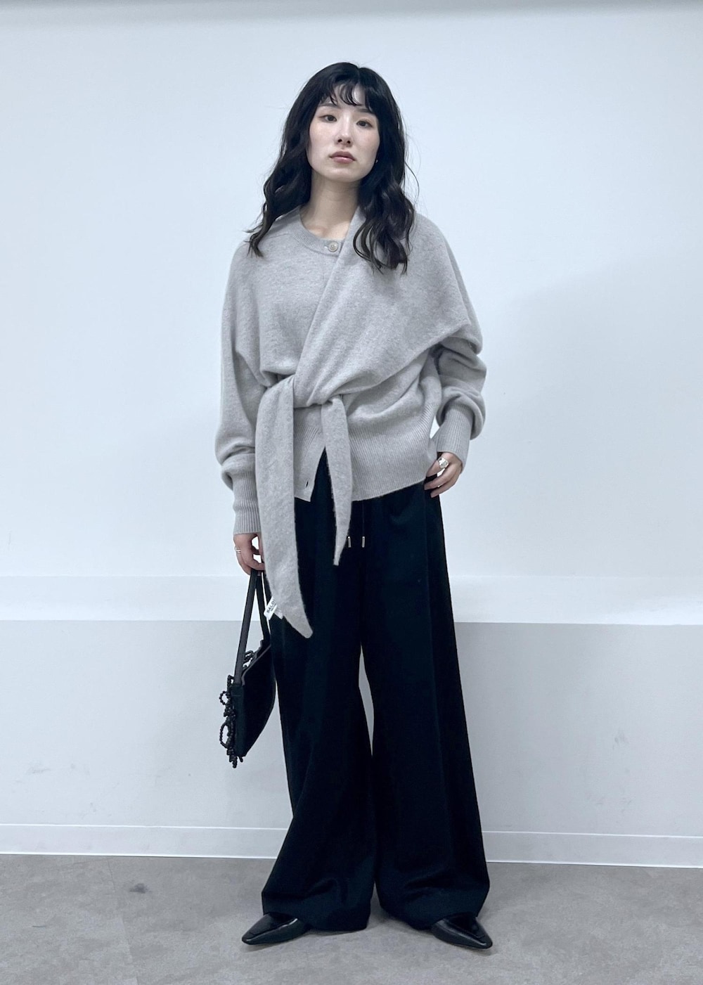 ベージュ系のカーディガン/ボレロ、ブラック系のその他パンツ、ブラック系のローファーを着用したレディースの秋コーディネートの2枚目の写真