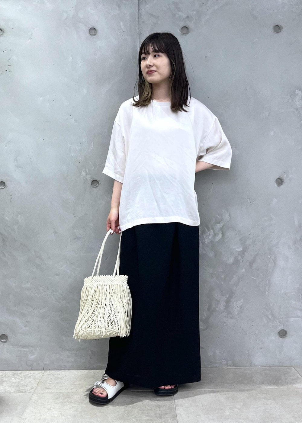 ホワイト系のTシャツ/カットソー、ホワイト系のサンダル、ホワイト系のトートバッグを着用したレディースの春コーディネートの2枚目の写真