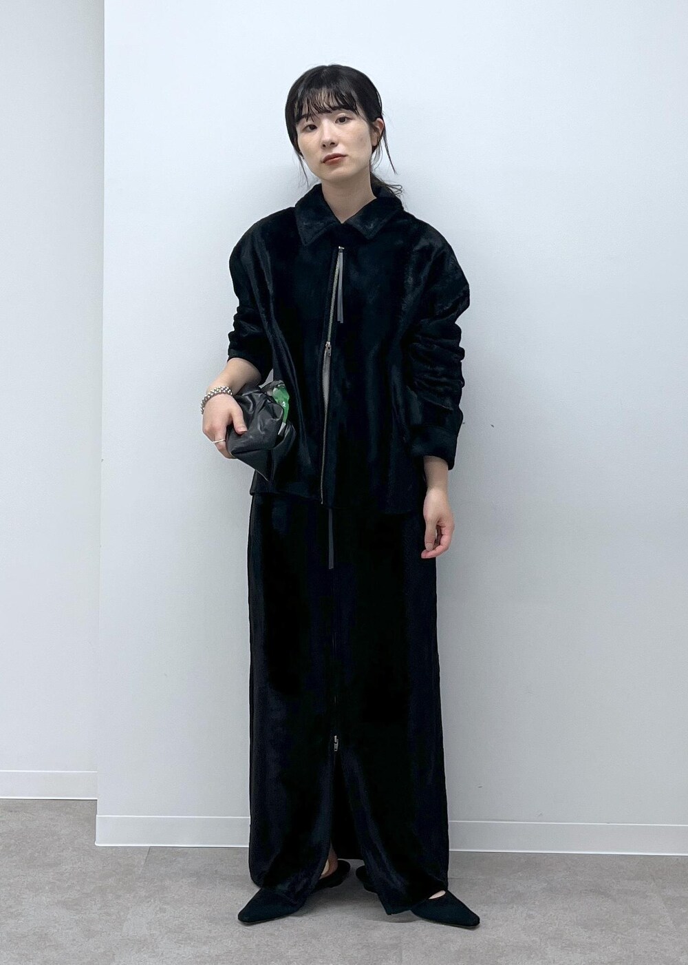 ブラック系のスカート、ブラック系のブルゾン、ブラック系のサンダルを着用したレディースの秋コーディネートの2枚目の写真