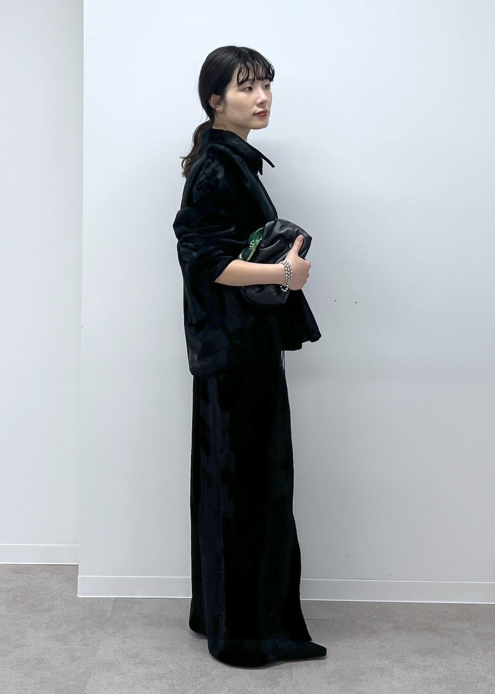 ブラック系のスカート、ブラック系のブルゾン、ブラック系のサンダルを着用したレディースの秋コーディネートの3枚目の写真