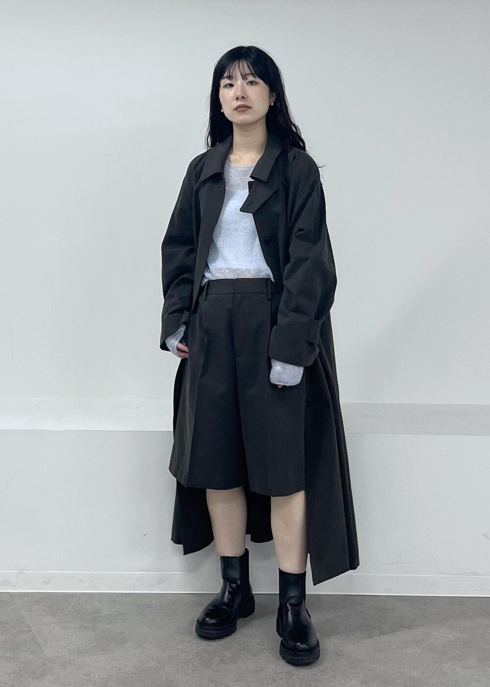 ブルー系のニット/セーター、グレー系のステンカラーコート、グレー系のその他パンツを着用したレディースの冬コーディネートの8枚目の写真