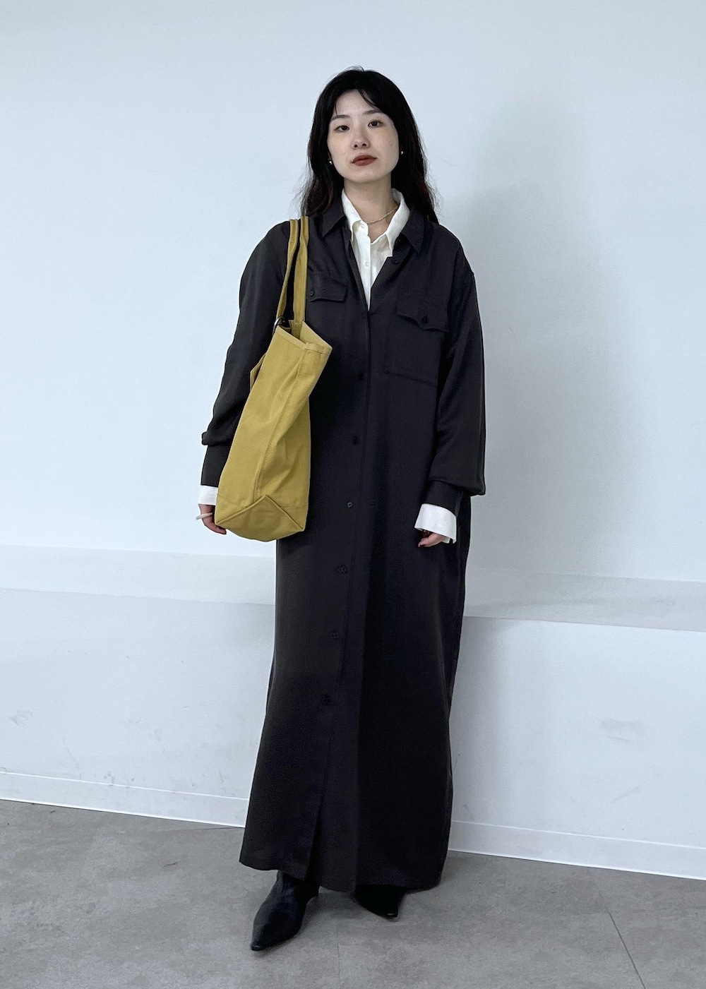 ホワイト系のシャツ/ブラウス、グレー系のワンピース、ブラック系のブーツを着用したレディースの秋コーディネートの2枚目の写真