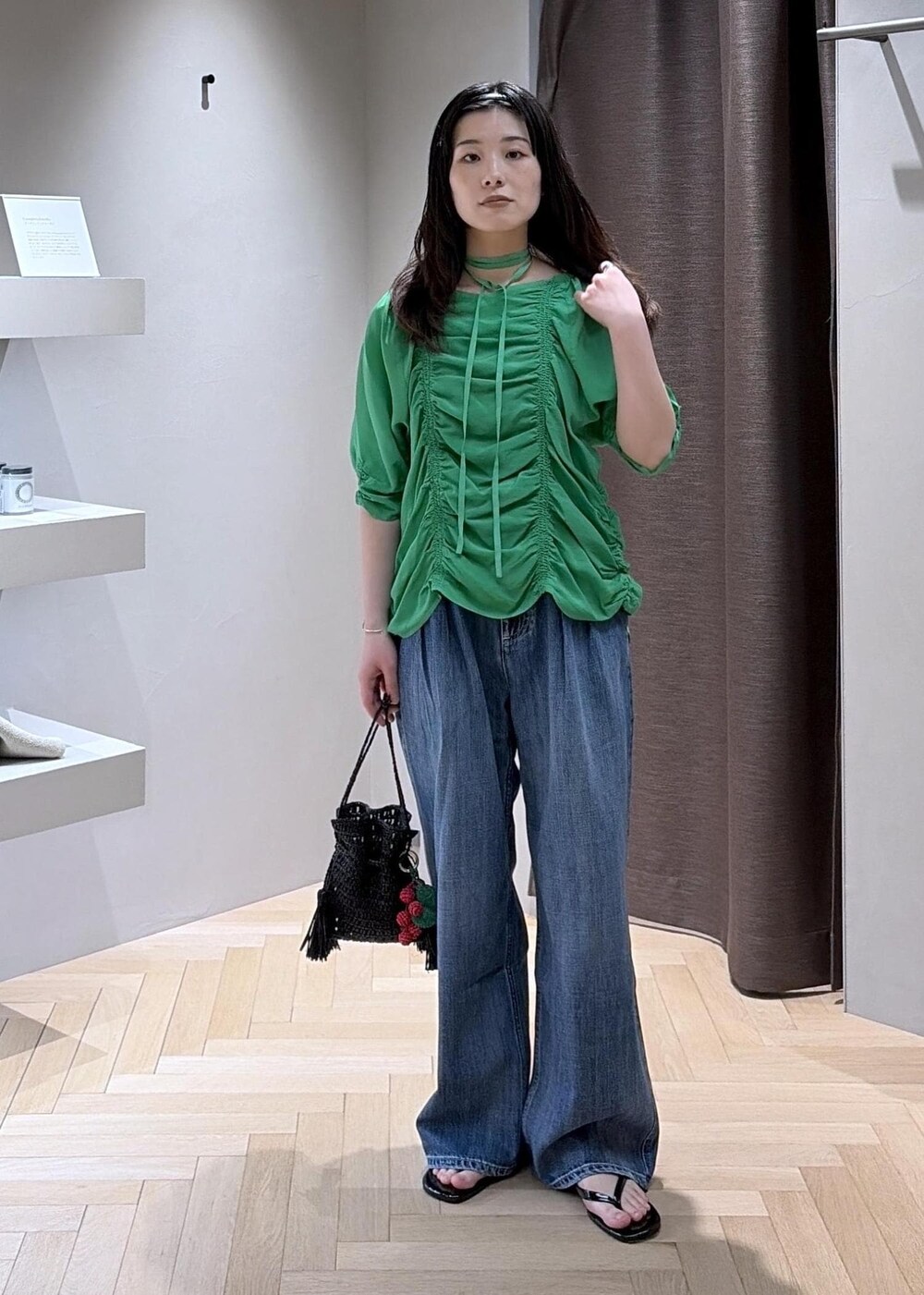 ブラック系のサンダル、ブルー系のデニムパンツ、ブラック系のハンドバッグを着用したレディースの春コーディネートの6枚目の写真
