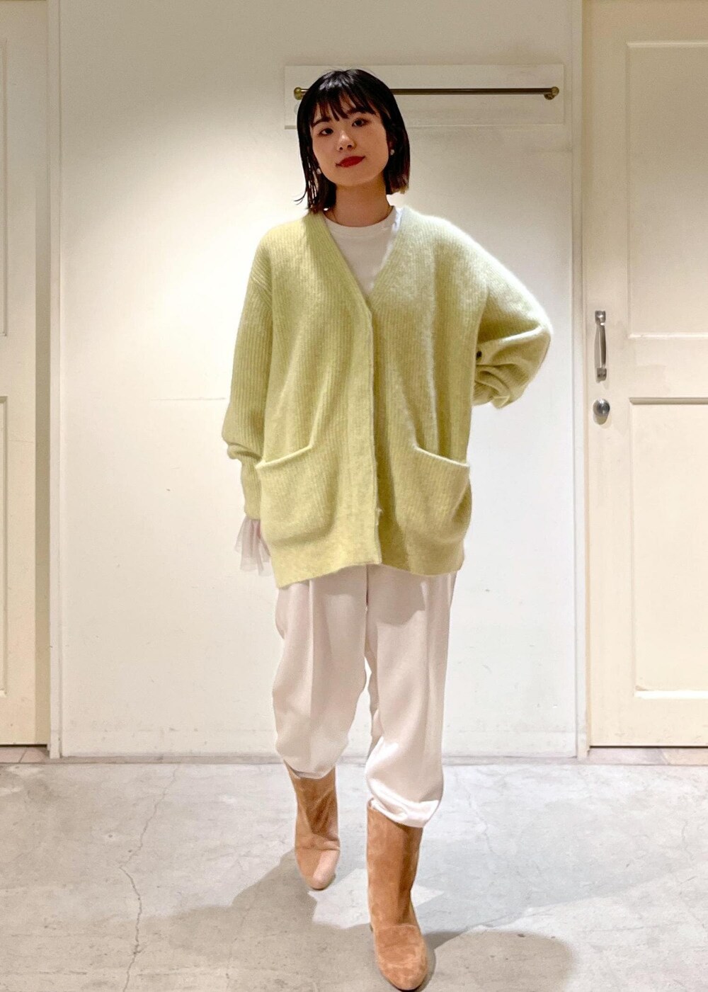 イエロー系のカーディガン/ボレロ、ブラウン系のブーツ、ホワイト系のその他パンツを着用したレディースの秋コーディネートの3枚目の写真