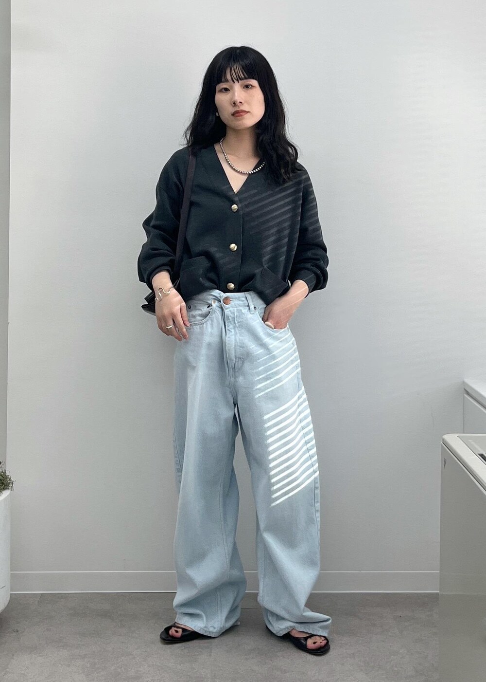 ブルー系のデニムパンツ、グレー系のカーディガン/ボレロ、ブラック系のショルダーバッグを着用したレディースの夏コーディネートの4枚目の写真