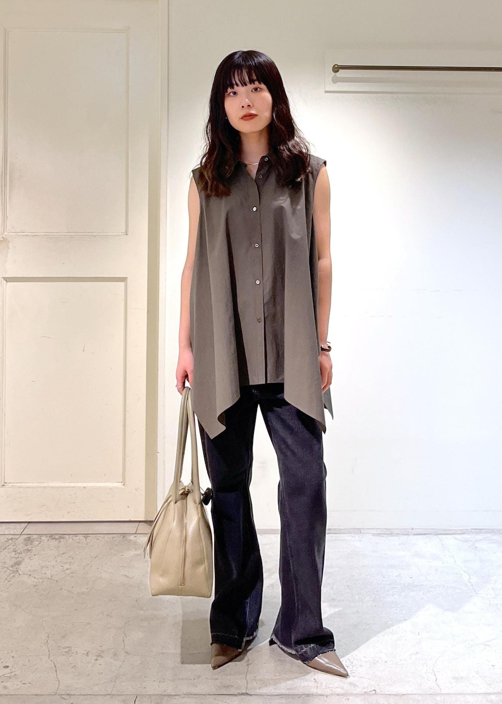 ベージュ系のボストンバッグ、グレー系のデニムパンツ、グレー系のシャツ/ブラウスを着用したレディースの夏コーディネートの7枚目の写真