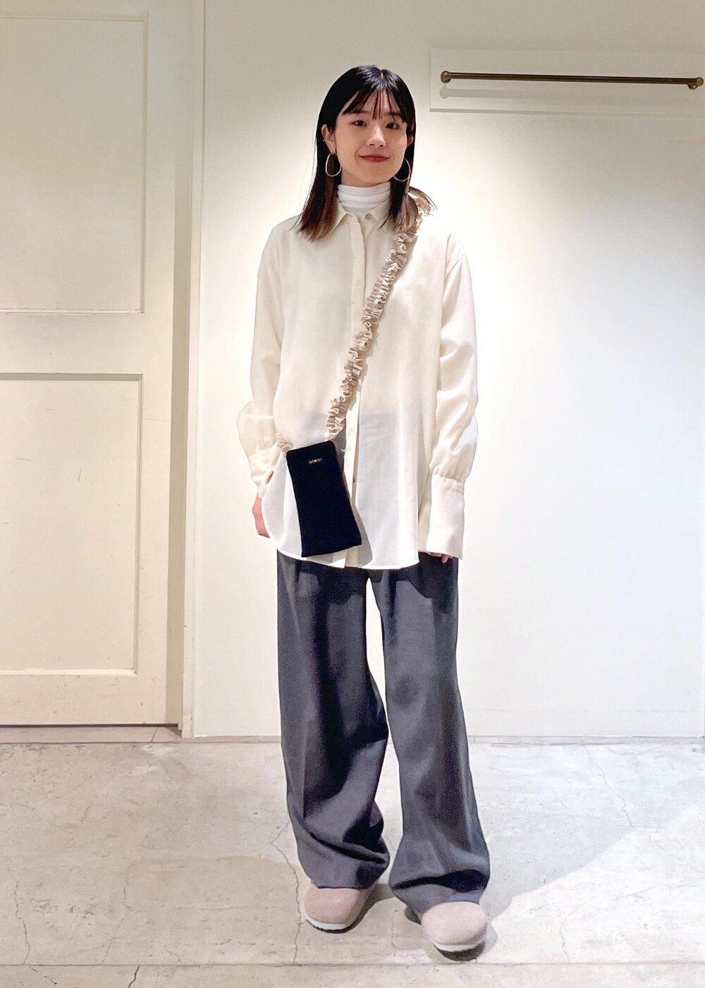 グレー系のサンダル、ホワイト系のシャツ/ブラウス、ホワイト系のTシャツ/カットソーを着用したレディースの冬コーディネートの2枚目の写真