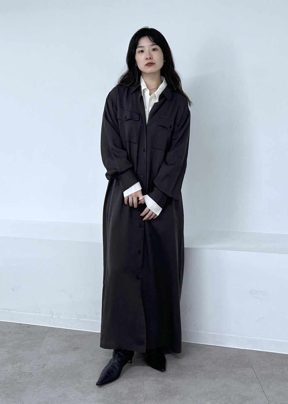 ホワイト系のシャツ/ブラウス、グレー系のワンピース、ブラック系のブーツを着用したレディースの秋コーディネートの7枚目の写真