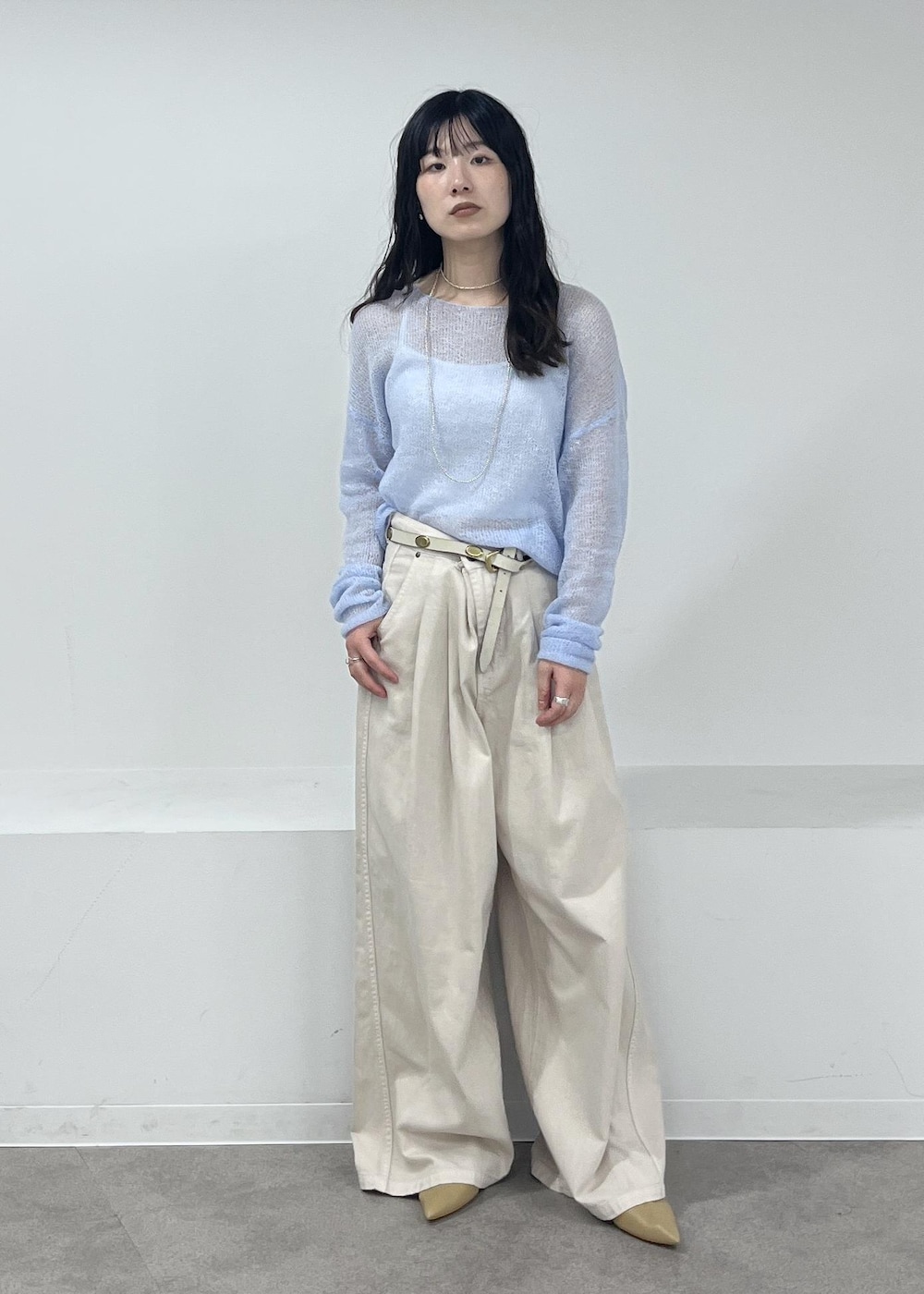 ホワイト系のデニムパンツ、ブルー系のニット/セーター、ベージュ系のパンプスを着用したレディースの冬コーディネートの3枚目の写真