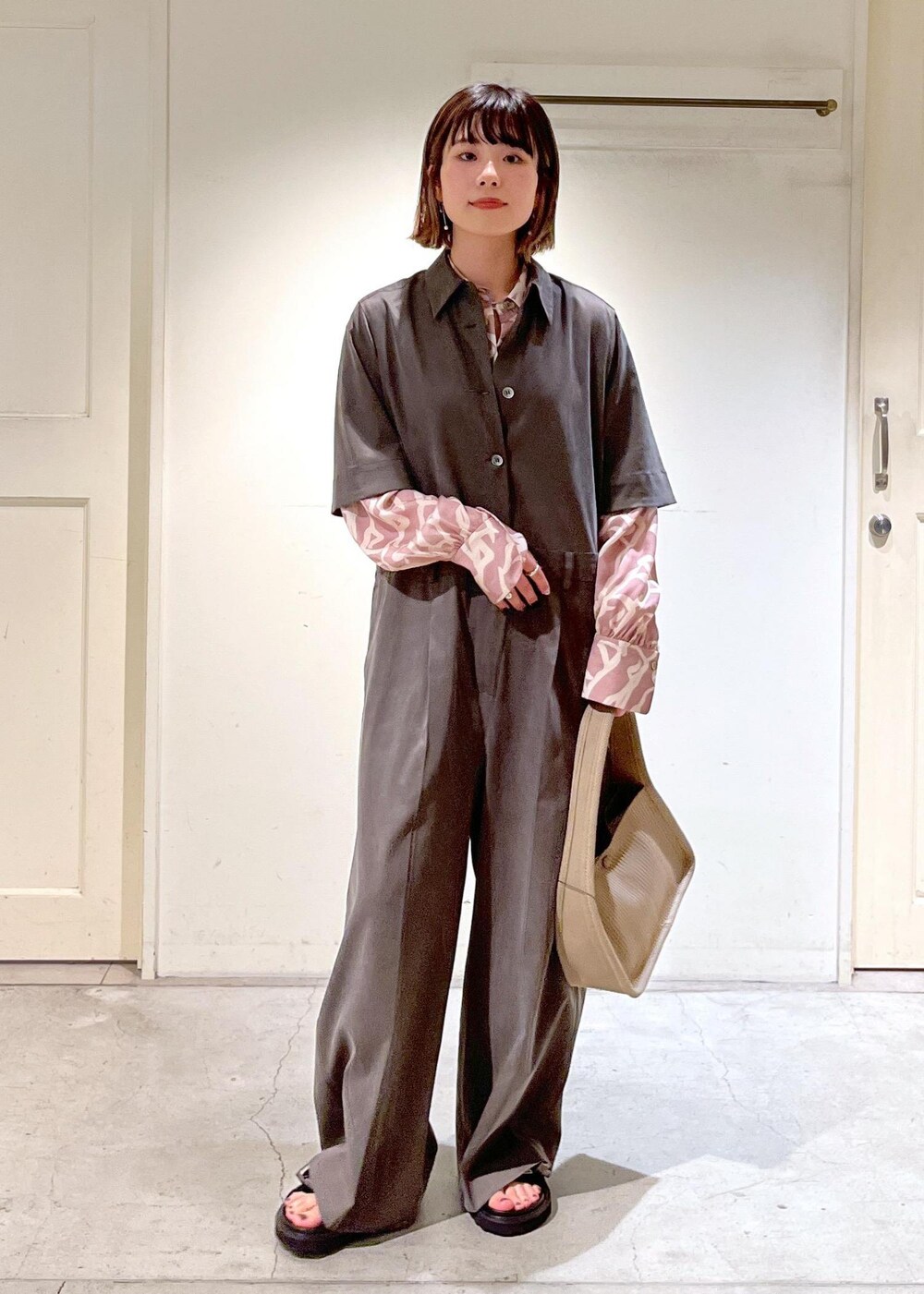 イエロー系のシャツ/ブラウス、ベージュ系のハンドバッグ、ブラック系のサンダルを着用したレディースの春コーディネートの3枚目の写真