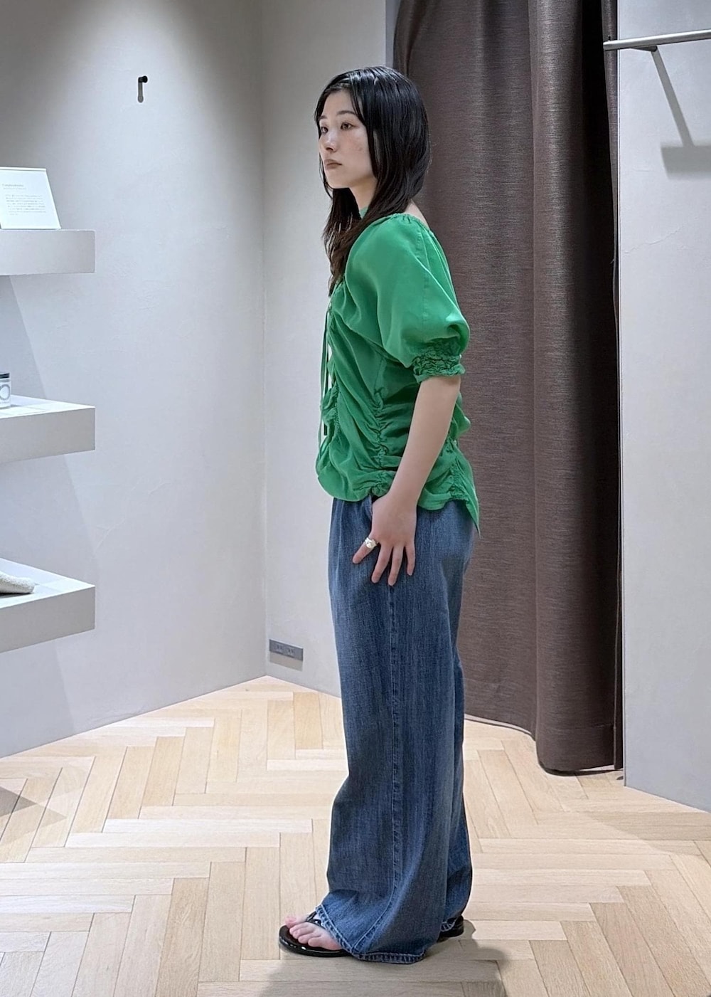 ブラック系のサンダル、ブルー系のデニムパンツ、ブラック系のハンドバッグを着用したレディースの春コーディネートの3枚目の写真