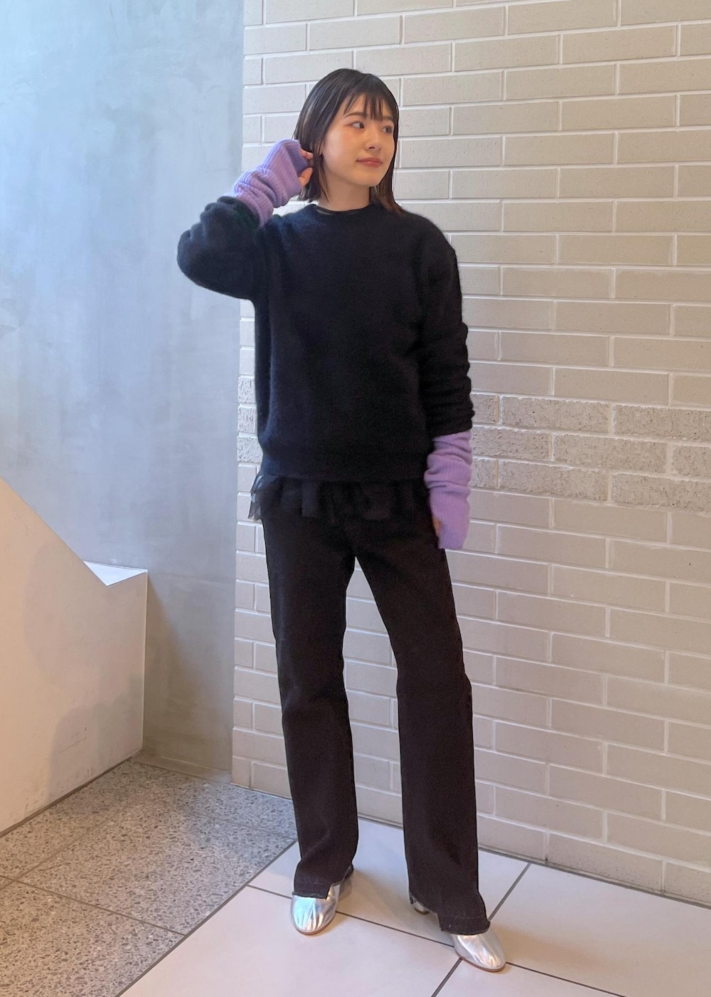 ブラック系のニット/セーター、ブラック系のベスト、グレー系のデニムパンツを着用したレディースの秋コーディネートの4枚目の写真